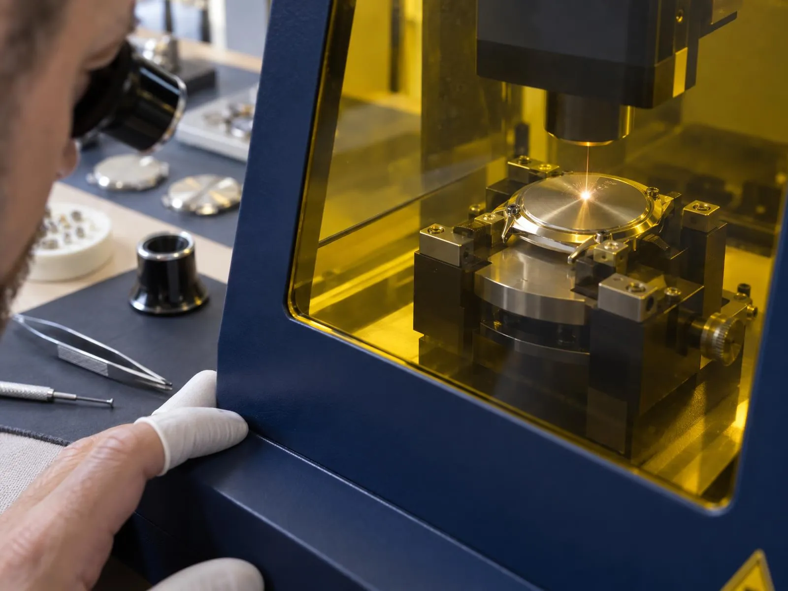 Gravure laser d'un fond de boîte de montre dans une station de marquage fermée, atelier d'horlogerie